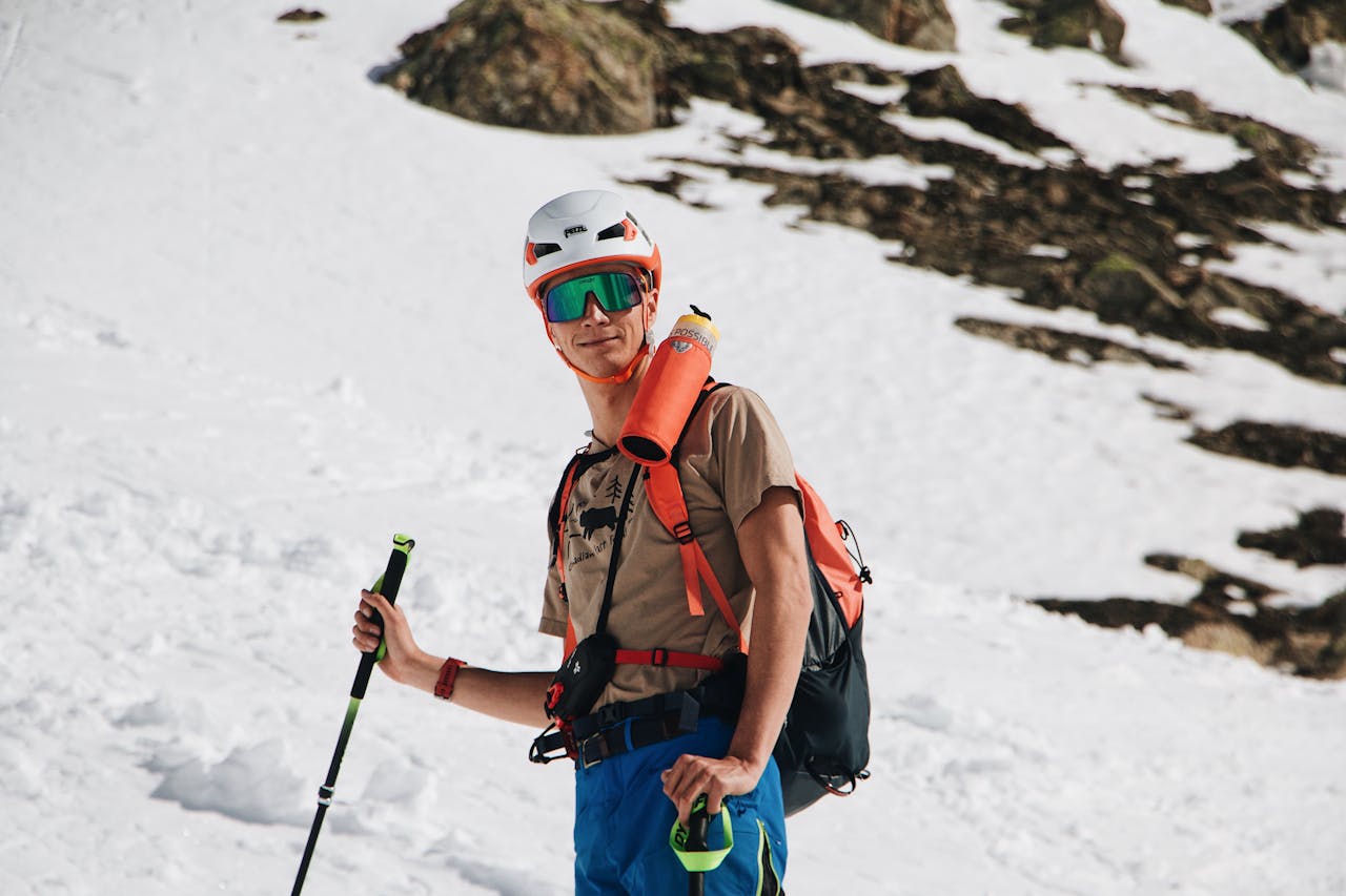 Home A man hiking in snowy mountains wearing gear, enjoying the winter sport.